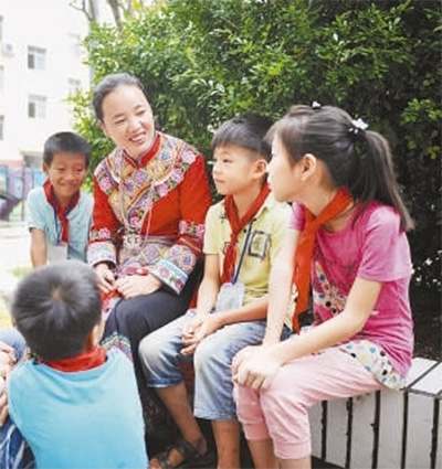 2017年10月，忻城县北更乡中心小学，蒙晓梅与爱心助养的学生交流。（蓝德龙 摄）