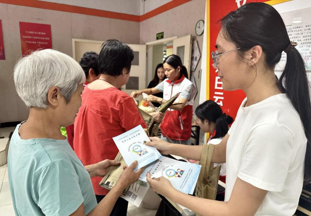 京溪街纪工委工作人员向在场的党员群众派发指南和宣传手册.jpg